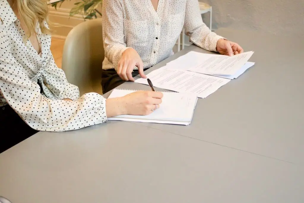 Two women meeting to fill out a contract—Stratice blog cover.