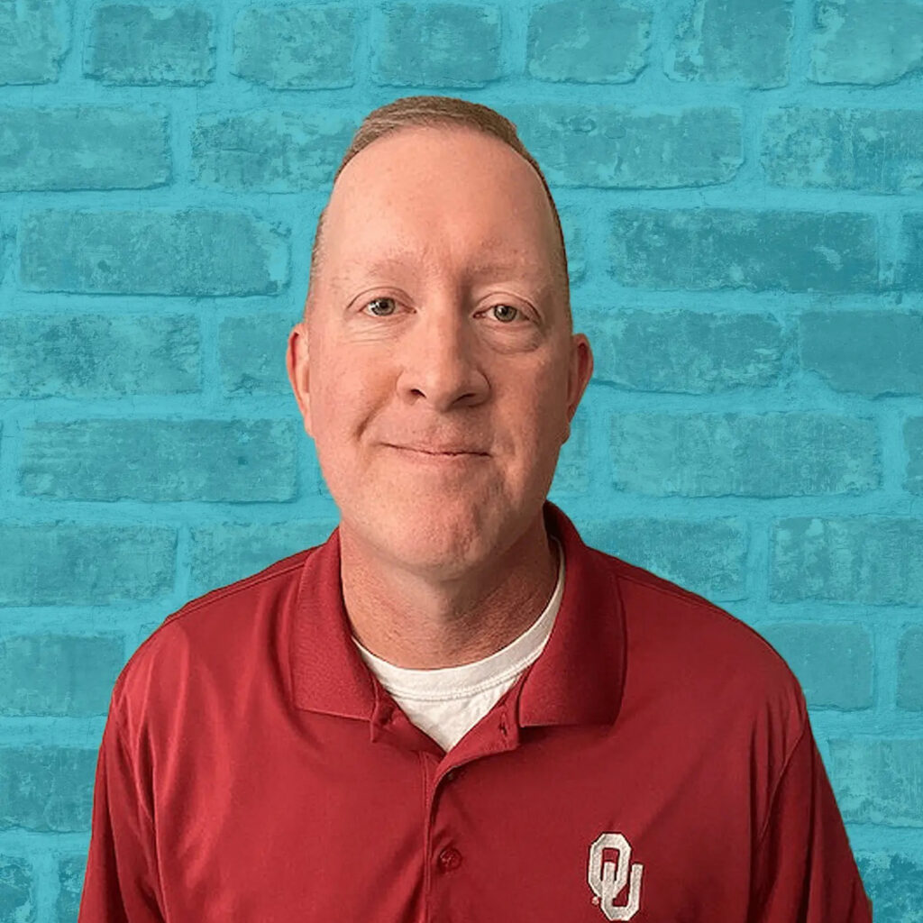 Headshot of Dave Salce, a senior recruiter at Stratice, in front of a blue wall.