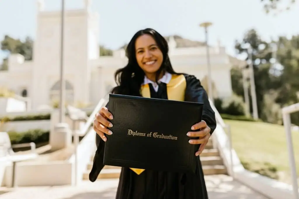 A recently graduated college student stands holding out her diploma to the camera. Stratice blog cover.